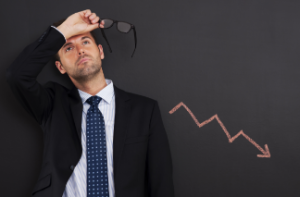 A stressed professional with a downward arrow graph in the background